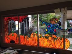 a stained glass window with an image of a scarecrow and pumpkins on it