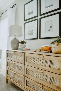 a dresser with pictures on the wall above it