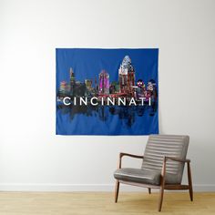 a chair sitting in front of a wall hanging with the word cincinali on it