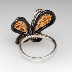 This exquisite butterfly ring is accented with seven (7), prong set, oval mixed cut natural spessartine garnet, two (2), prong set, round mixed cut natural spessartine garnet and one hundred forty-seven (147), bead/prong set, round brilliant cut diamonds. The ring measures 21.7mm at the top, rises 10.2mm above the finger, tapering to 3.5mm wide and 1.1mm thick at the base of the shank. This ring is currently a size 8.25. Luxury Butterfly Ring For Wedding, Luxury Butterfly Ring For Formal Occasions, Luxury Butterfly Ring For Anniversary, Diamond Butterfly Ring With Gemstone For Formal Occasions, Formal Diamond Butterfly Ring With Gemstone, Luxury Diamond Butterfly Ring For Formal Occasions, Elegant Butterfly Shaped Rings, Formal Butterfly Gemstone Ring In Fine Jewelry Style, Elegant Round Butterfly Ring For Formal Occasions