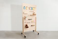 a white pegboard with several items on it and a teddy bear sitting in front of it