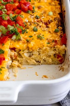 a casserole dish with tomatoes, onions and cheese