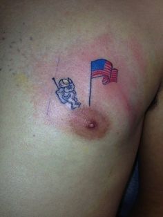 a man with a small tattoo on his chest holding a red and blue american flag