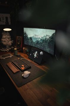 A moody home office setup featuring a dark wooden desk and nature-inspired wallpaper. The workspace includes a mechanical keyboard, a white ergonomic mouse, and ambient lighting, creating a cozy and sophisticated atmosphere. Dark Wooden Desk, Moody Home Office, Computer Desk Organization, Moody Home, Photography Reference, Gaming Rooms, Gaming Desk Setup, Cozy Desk, Solid Snake