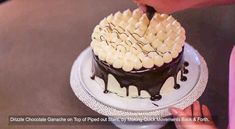 a person cutting into a chocolate cake with white icing