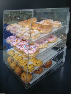 a display case filled with lots of different types of doughnuts on top of each other