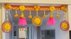 decorations are hanging from the ceiling in front of a door with pink and yellow tassels