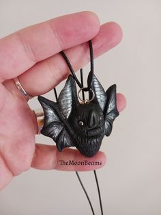 "Hand-painted polymer clay Black and Silver bat pendant necklace MADE TO ORDER PROCESSING TIME 1-2 WEEKS It will be created for you, just like the one in the pictures, please allow slight variations due to the handmade nature of the piece, which makes each bat unique :) The new version of my classic Chubby Bat pendant Made by me using Black polymer clay,with silver accents(wings and ears) With Hematite eyes. It is 2\" wide and 2\" tall the back is flat It comes with a black cotton cord 18\" with Handmade Resin Jewelry For Halloween, Spooky Black Necklace For Gift, Handmade Black Jewelry For Cosplay, Hand Painted Black Resin Jewelry, Hand Painted Black Polymer Clay Jewelry, Handmade Black Necklace For Cosplay, Handmade Polymer Clay Halloween Jewelry, Unique Black Halloween Necklace, Hand Painted Black Pendant Jewelry