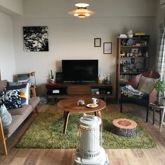 a living room filled with furniture and a flat screen tv on top of a wooden table