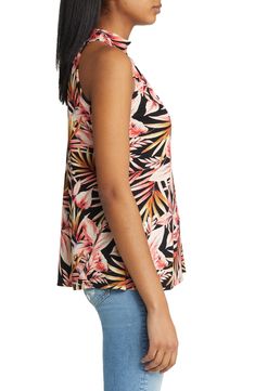 Amp up your day-to-night look in a jersey mock-neck halter top featuring an alluring cutout and a pretty palm print. 25" length Mock neck Sleeveless, with cutaway shoulders 95% rayon, 5% spandex Machine wash, dry flat Imported Floral Print Stretch Tops For Vacation, Vacation Floral Print Halter Neck Top, Black Tropical Tops For Spring, Tropical Black Tops For Spring, Spring Tropical Black Top, Chic Graphic Print Top For Vacation, Black Tropical Print Top, Black Tropical Style Tops With Tropical Print, Black Tropical Print Casual Tops