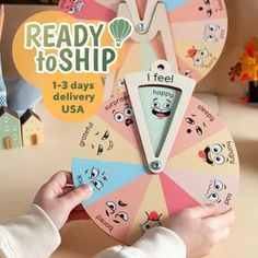 a child is playing with a toy wheel that has faces on it and the words ready to ship