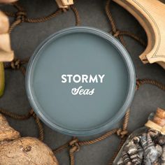 a round sign that says stormy seas next to other items on a roped surface