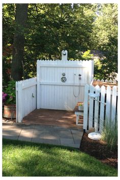 a white fenced in area next to a tree