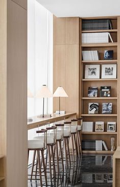 a room filled with lots of books and chairs next to a counter topped with pictures