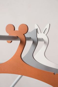 an orange and silver mickey mouse hook on a white wall next to a gray rabbit