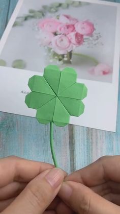 someone is making a four leaf clover out of paper