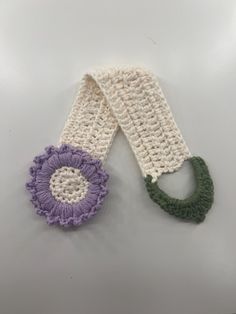 two crocheted scarves one with a flower and the other with a ring