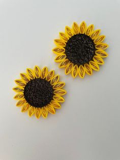 two yellow and black sunflowers on a white surface