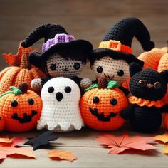 crocheted pumpkins with black cats and witches on them, all in different sizes