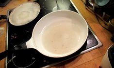 two pans sitting on top of an electric stove with one being used as a frying pan