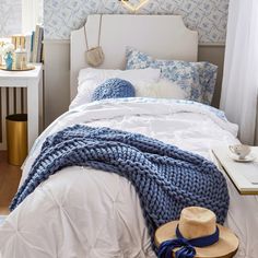 a white bed with blue and white decor