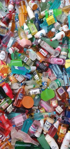 many different types of medicine bottles are piled on top of each other in this pile