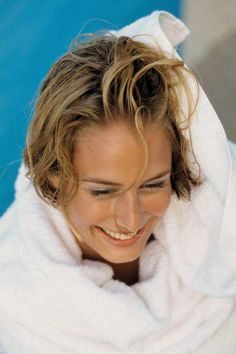 a woman wrapped in a white towel smiling