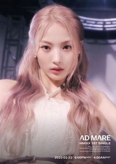 a woman with long pink hair standing in front of a stage wearing a white dress