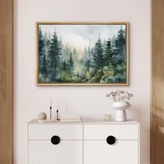 a painting hanging above a white dresser in a room with wood paneling and drawers