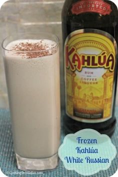 a bottle of kahlua next to a glass filled with ice cream and cocoa