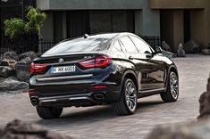 a black bmw suv parked in front of a building