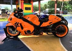 an orange motorcycle parked in a parking lot