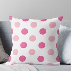 a pink and white polka dot pattern on a pillow sitting on top of a couch