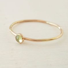 A lovely peridot gemstone has been encased in 14k gold filled and set on a 14k gold filled stacking ring. Band measures 1mm thick. Stone measures 3mm. Ring is available in all sizes. Yellow Gold Stackable Rings With Peridot, Green Stackable 14k Gold Jewelry, Stackable Yellow Gold Peridot Jewelry, Stackable Green 14k Gold Jewelry, Everyday Green 14k Gold Stackable Rings, Yellow Gold Peridot Stackable Rings, Green Peridot Stackable Promise Rings, Gold Peridot Ring For May Birthstone, Everyday Green Gemstone Stackable Rings