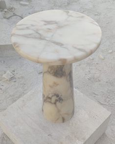 a marble table sitting on top of a white block