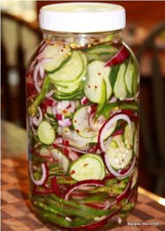 a jar filled with sliced up vegetables sitting on top of a table