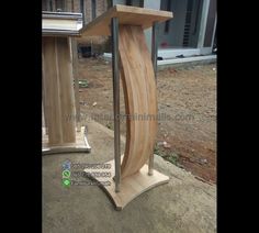 a wooden podium sitting on top of a cement floor next to a building with windows