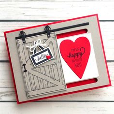 a red and white card with an image of a heart hanging from the side on a wooden background