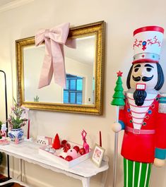 a nutcracker is standing in front of a mirror and christmas decorations on a table