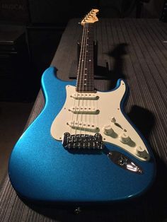 a blue electric guitar sitting on top of a table