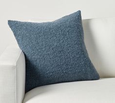 a blue pillow sitting on top of a white couch