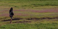 a person standing in the middle of a field with a backpack on their back,