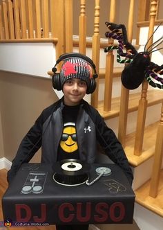 a young boy wearing headphones sitting on top of a table with a record player