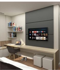 a bedroom with a bed, desk and television in it's center wall that has bookshelves on the other side