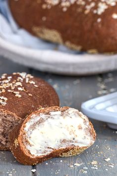 two loaves of bread with cream cheese on top and one loaf cut in half