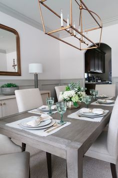 the dining room table is set with white plates and place settings for four people to eat