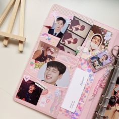 a pink binder with photos and magnets on it next to a pair of scissors