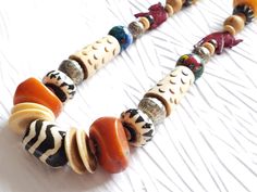 Limited Edition. Only 1 in stock.Who doesn't love an organically beautiful necklace that's light and eclectic? The Juke Joint necklace is exactly that and more. Made with repurposed beads from a vintage carved bone necklace, I took some of those elements and fashioned them into a stylishly bohemian look by adding in some great bold color elements of warm orange and yellow copal amber resin, hand-blown lampwork glass bead orbs, a batik bone focal and fun maroon carved red elephant collarbone foca Nature-inspired Necklace With Large Beads For Gifts, Bohemian Beaded Necklace With Natural Variations, Bohemian Beaded Necklaces As Gift, Red Elephant, Juke Joints, Amber Resin, Bone Necklace, African Necklace, Carved Bone