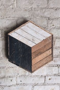 a wooden block mounted to the side of a brick wall with wood planks on it