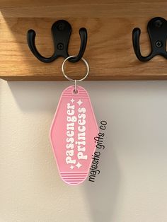 a pink keychain hanging from a wooden coat rack